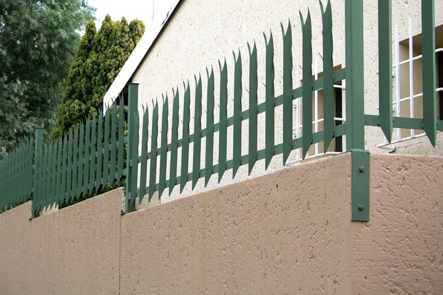 Palisade fencing mounted on top of a boundary wall