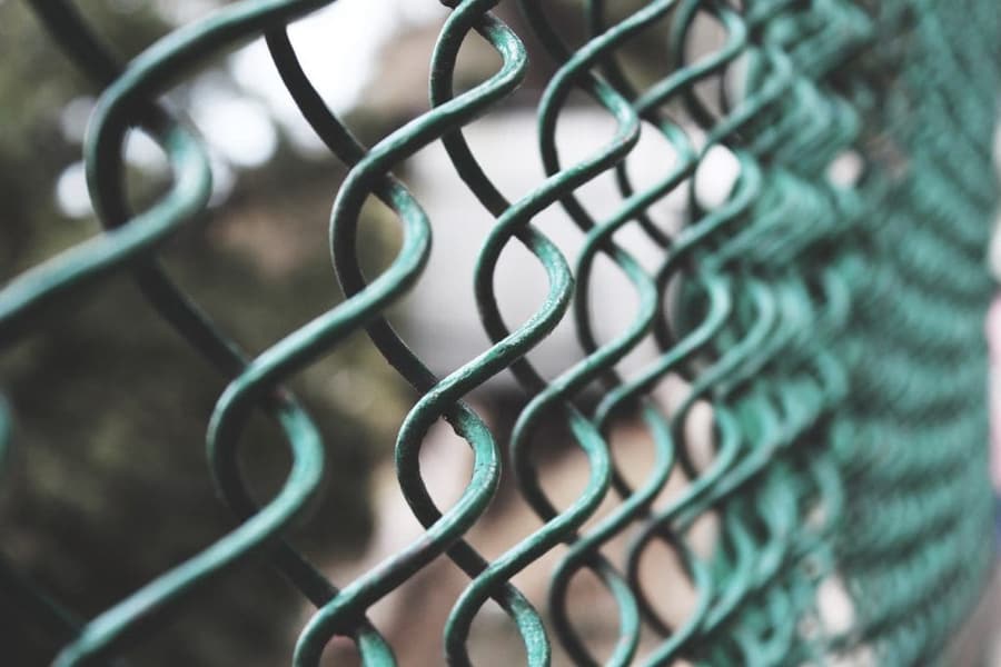 Green mesh fencing around a tennis court