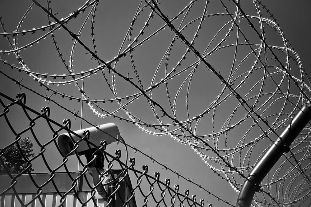 Barbed and razor wire on black security fencing